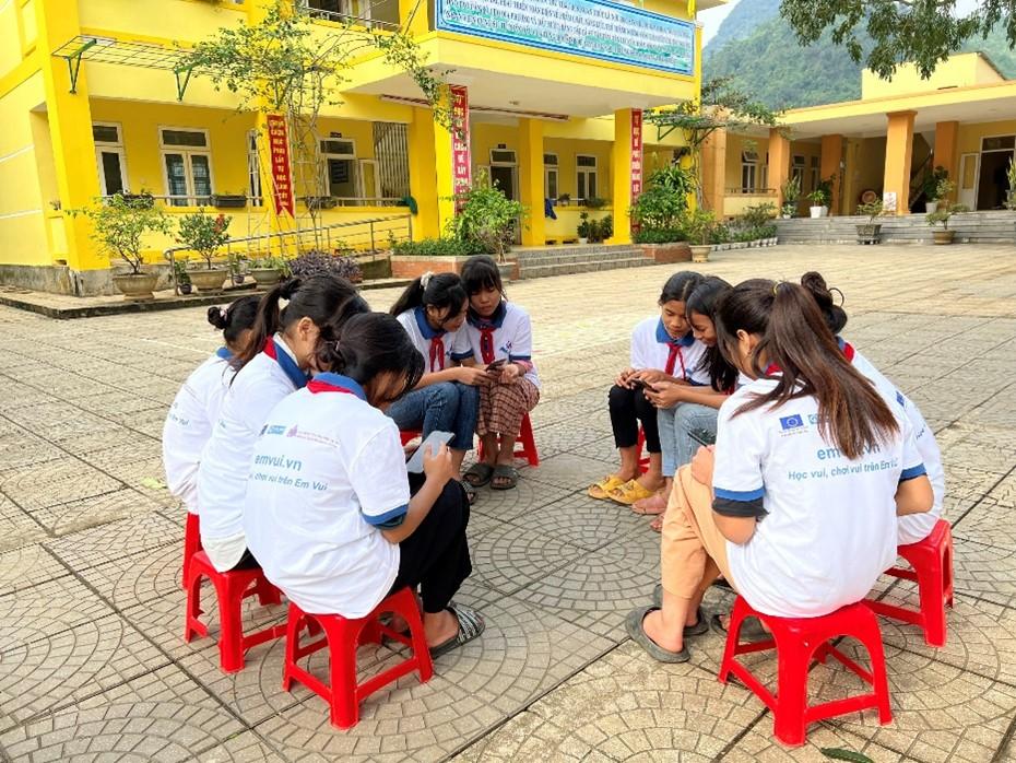 Project participants exchanging on the online content of Em Vui